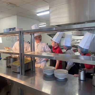 Tutor Glenydd Hughes teaching cooking skills to Year 5 and 6 pupils