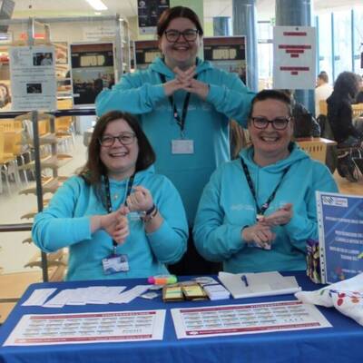 Staff signing at the Sign Language Week stall at Coleg Llandrillo